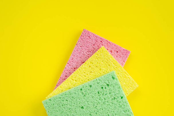 Three kitchen rag lying on yellow background. Top view - Foto, afbeelding