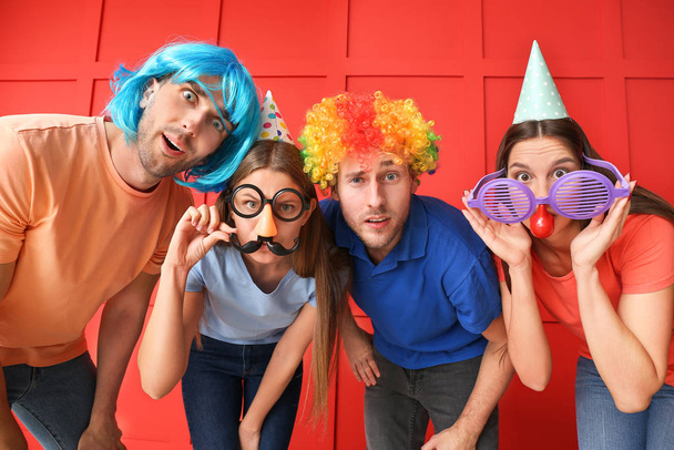 Gente disfrazada de gracioso sobre fondo de color. Celebración del Día de los Inocentes
 - Foto, imagen