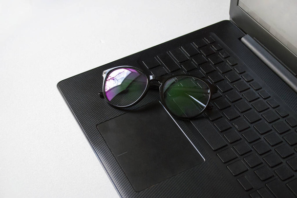 Área de trabalho com um laptop. Óculos de segurança para trabalhar em um computador
. - Foto, Imagem