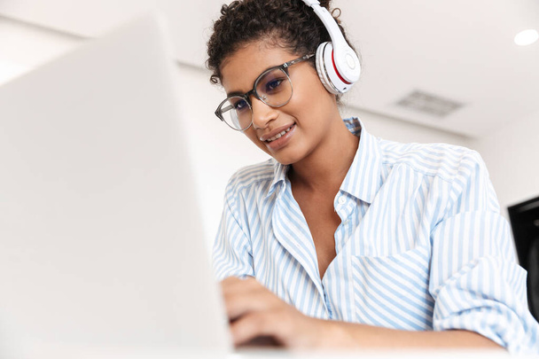 Attractive young african woman working on laptop computer - Foto, Bild