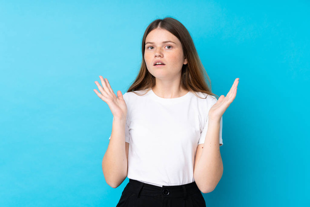 Ukrainian teenager girl over isolated blue background with surprise facial expression - Foto, imagen