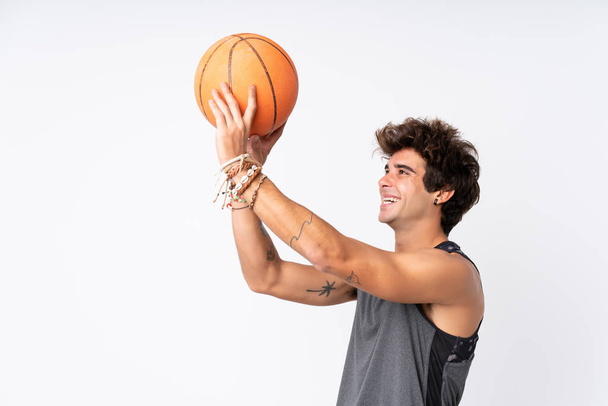 Young caucasian man over isolated white background playing basketball - Фото, зображення