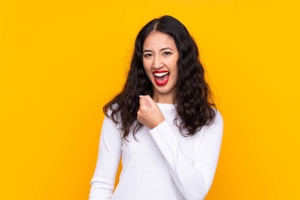 Mixed race woman over isolated yellow background celebrating a victory - Photo, Image