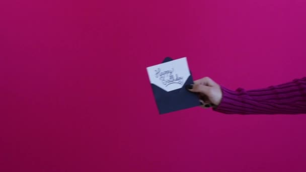 Women hands and arms exchanging happy birthday card with saturated pink backgrou - Πλάνα, βίντεο