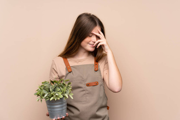 Adolescente ucraniana jardinero chica sosteniendo una planta riendo
 - Foto, imagen