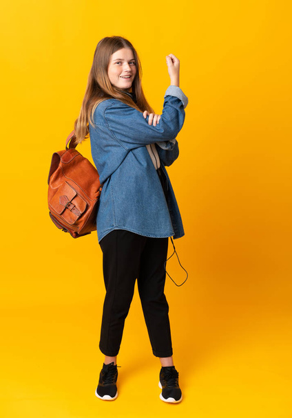 Estudiante ucraniano adolescente chica sobre aislado amarillo fondo haciendo fuerte gesto
 - Foto, Imagen