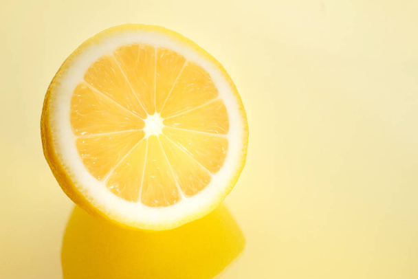 Sarı arka planda dilimlenmiş parlak sulu limon.. - Fotoğraf, Görsel