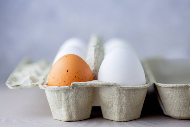 Eggs in a box of different colors. Protein. Healthy foods. Healthy food. Eggs for breakfast. Eggs in the refrigerator on the shelf. Box with eggs on a gray background - Photo, Image