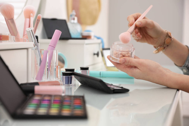 Woman applying makeup at dressing table, closeup - Fotografie, Obrázek