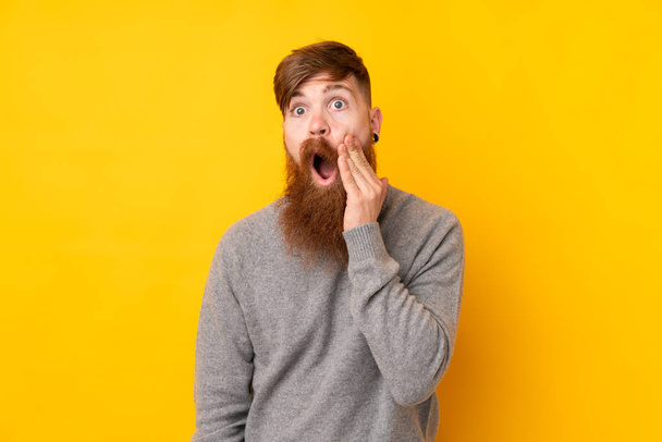 Рыжий с длинной бородой на изолированном желтом фоне с удивлением и шокированным выражением лица
 - Фото, изображение