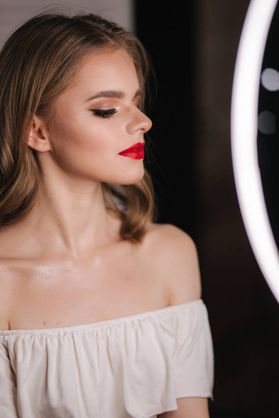 Portret van een mooie blonde haardame na make-up in de schoonheidssalon. Rode lippenstift. Ringlicht - Foto, afbeelding
