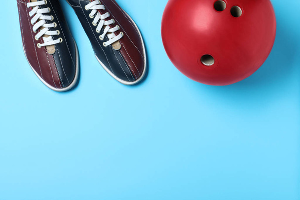 Bowling ball and shoes on light blue background, flat lay. Space - 写真・画像