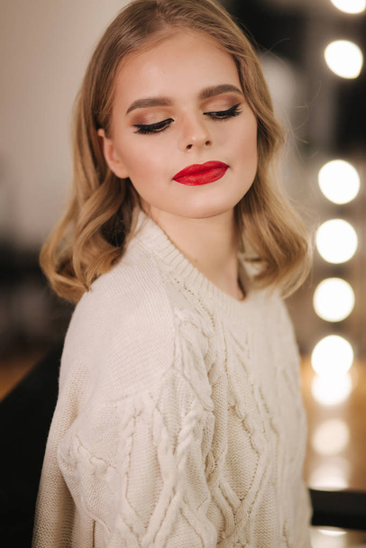 Attractive young lady in beauty studio after makeup. Beautiful woman with red lipstick - Foto, imagen