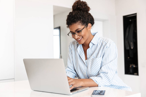 Attractive young african woman working on laptop computer - Foto, Bild