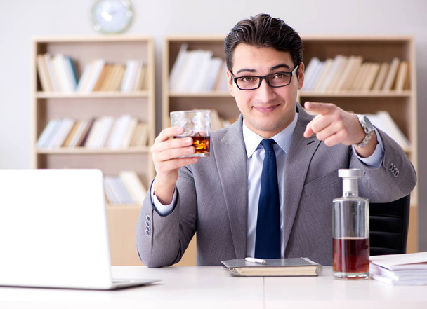Young businessman drinking from stress - Фото, изображение