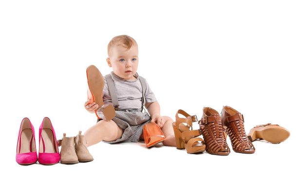 Cute baby with stylish female shoes on white background - Photo, Image
