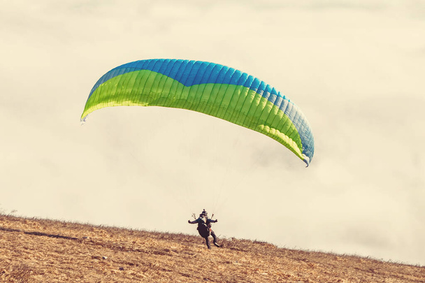 paraglider starting to paragliding above mountain - 写真・画像
