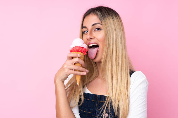 Mladá uruguayská žena s kornetovou zmrzlinou na izolované růžové - Fotografie, Obrázek