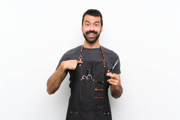 Homem barbeiro em um avental com expressão facial surpresa
 - Foto, Imagem