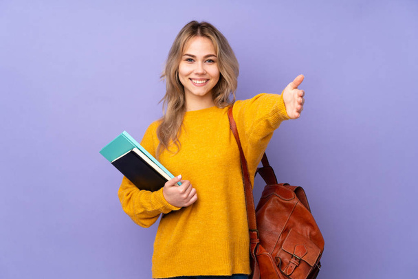 Teenager ruské studentské dívka izolované na fialové pozadí prezentaci a pozvání přijít s rukou - Fotografie, Obrázek