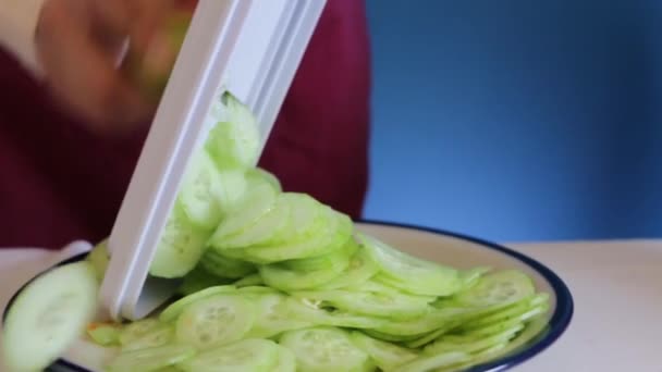 Close up of chopping cucumber with mandolin slicer,  handheld shot - Video, Çekim