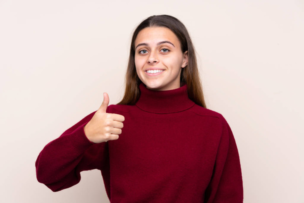 Teenager girl over isolated background giving a thumbs up gesture - Foto, Bild