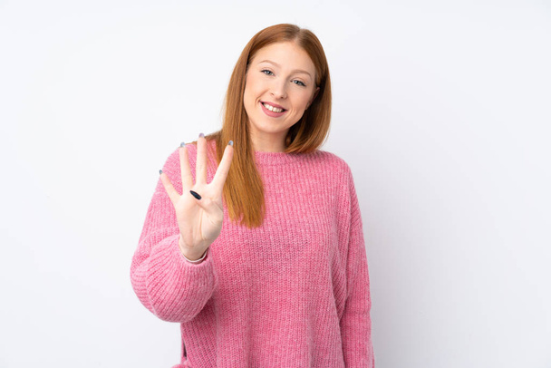 若いですredhead女性とともにピンクセーター上の隔離された白い背景幸せとカウント4とともに指 - 写真・画像