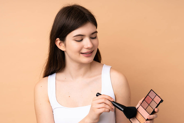 Junge ukrainische Teenager Mädchen über isolierten Hintergrund mit Make-up-Palette - Foto, Bild