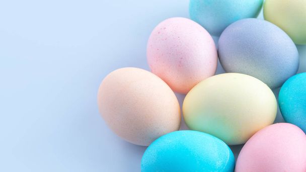 Colorful Easter eggs dyed by colored water isolated on a pale blue background, design concept of Easter holiday activity, close up, copy space. - Photo, image