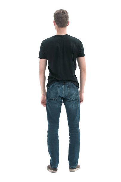 rear view. guy in black t-shirt staring at blank wall. - Фото, зображення