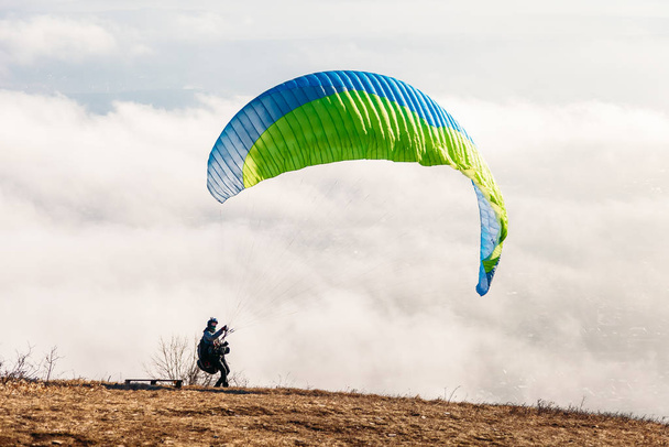 Pyatigorsk, Stavropol Territory / Russia - January 21, 2019: paraglider starting to paragliding above mountain - Foto, Imagen