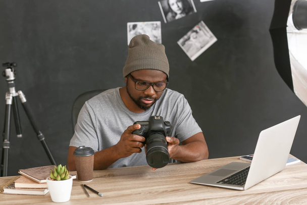 Fotografo afro-americano a tavola in studio
 - Foto, immagini