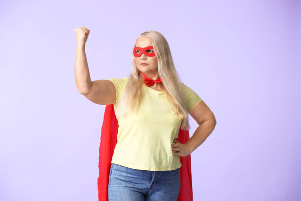 Žena v kostýmu superhrdiny na barevném pozadí. Koncept feminismu - Fotografie, Obrázek
