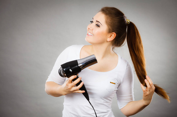 Woman drying her hair using hair dryer - Foto, immagini