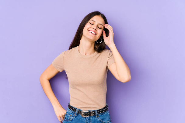 Young caucasian woman isolated on purple background joyful laughing a lot. Happiness concept. - Photo, Image