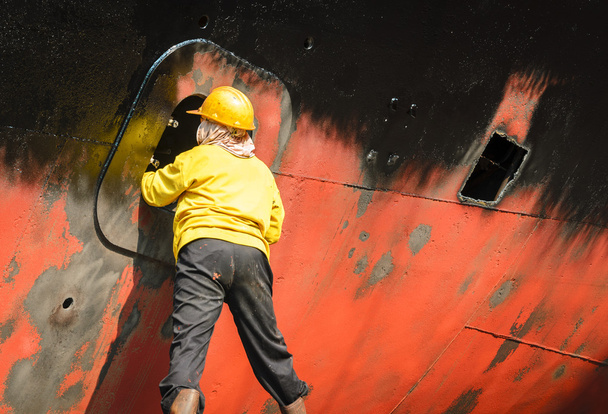 pracownik do czyszczenia części statków w stoczni - Zdjęcie, obraz