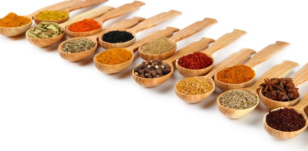 Assortment of spices in wooden spoons, isolated on white - Photo, image