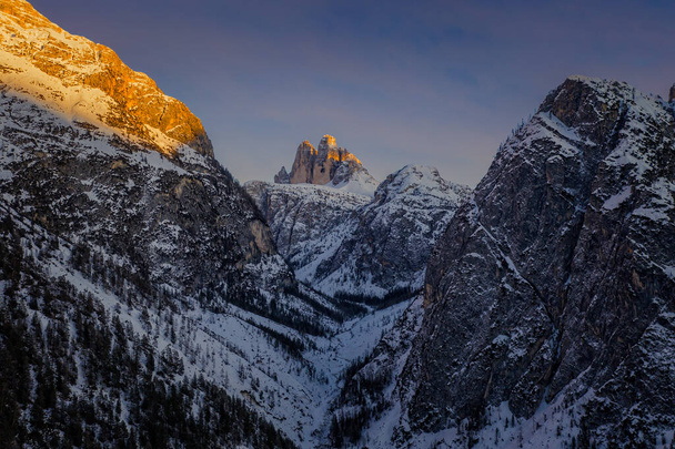 farbenfroher Sonnenuntergang in den Dolomiten, drei Gipfel des tre cime di lavaredo im verschneiten und bewölkten Hintergrund. Italien, Europa. Januar 2020 - Foto, Bild