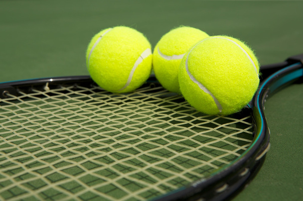 tennisballen op een racket - Foto, afbeelding