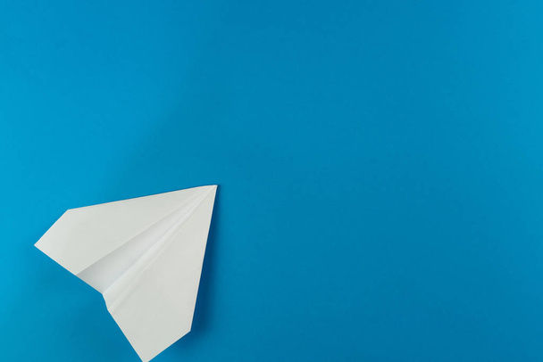 Handmade white paper plane on blue background - Foto, imagen