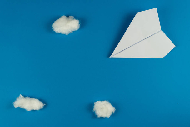 Бумажный самолет ручной работы на синем фоне
 - Фото, изображение