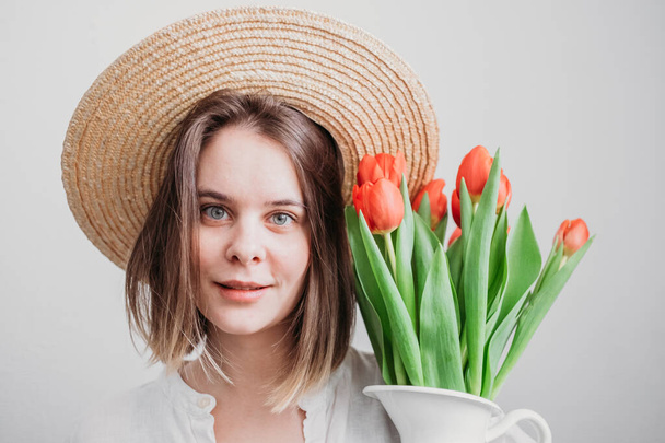 young woman in hat with red tulip bouquet  - Foto, immagini