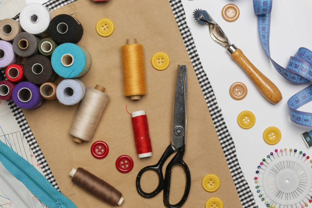 Conjunto de diferentes itens de costura vista superior de tesouras, fios, botões, agulhas de costura, tecido e padrões
 - Foto, Imagem