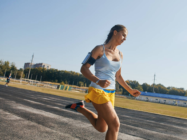 girl is keenly jogging in the stadium - Valokuva, kuva