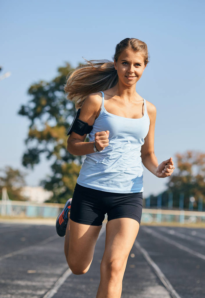 girl is keenly jogging in the stadium - Photo, image
