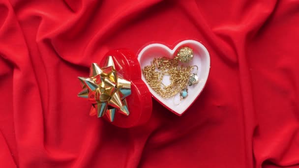 Close up of jewelry in heart shaped box on red satin - Footage, Video