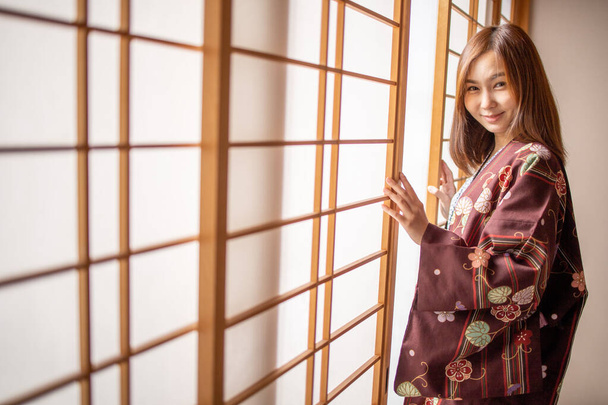 Lovely Asian Girl noszenie Yukata japońskiej tradycyjnej tkaniny w stylu traddition Japonii w pokoju Tatami. Twarz na szczęśliwy czas w Japonii z miejsca do kopiowania. - Zdjęcie, obraz