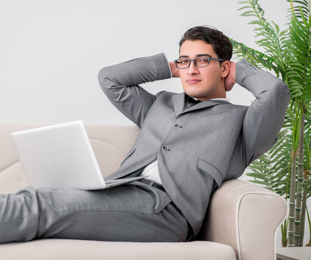 Молодой бизнесмен лежит на диване - Фото, изображение