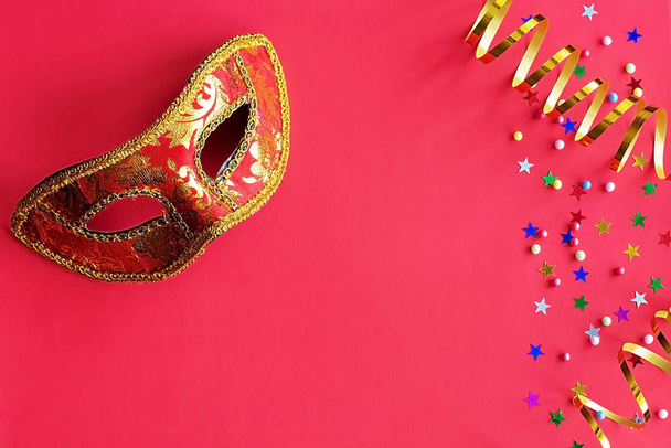 Kırmızı arka planda dekor olan şenlik maskesi. Karnaval kutlaması konsepti, Mardi Gras, Brezilya karnavalı, Venedik karnavalı, karnaval kostümü, bahar. Düz konum, üst görünüm, metin için yer - Fotoğraf, Görsel