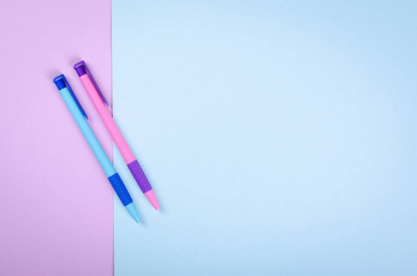 Різні кольорові ручки, шкільна куля на фіолетовому фоні композиції
. - Фото, зображення